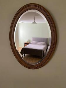 une chambre avec un lit et un miroir au mur dans l'établissement Gîte à Rocamadour, à Rocamadour