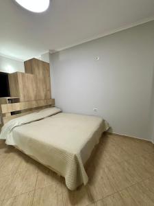 a bedroom with a bed in a white room at Roses Place Golem in Golem