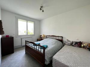 ein Schlafzimmer mit zwei Betten und einem Fenster in der Unterkunft Maison de Famille à Soulier in Gramat