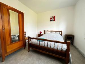 Schlafzimmer mit einem Holzbett und einem Spiegel in der Unterkunft Maison de Famille à Soulier in Gramat + 6 Fotos