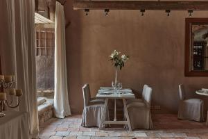 ein Esszimmer mit einem Tisch mit einer Vase mit Blumen in der Unterkunft Casa Taberna in Pedraza