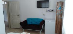 a living room with a blue chair and a television at GEYİKLİ BULUT Pansiyon in Ezine