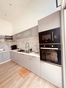 y cocina con microondas y fregadero. en DOMAINE LES ATELIERS et SPA, en Antananarivo 22 fotos más