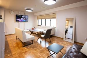 a living room with a table and chairs at エレガンス表町-市内中心部でアクセス良好 ワンフロア貸し切りでパーティもOｋ駐車料金無料 in Okayama