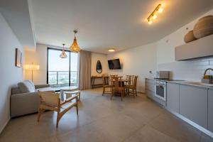 a kitchen and living room with a table and chairs at Maui Apartment-By Harim in Eilat