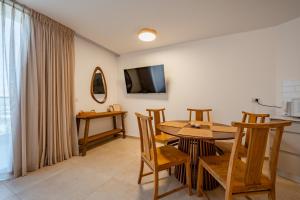 a dining room with a table and chairs and a television at Maui Apartment-By Harim in Eilat