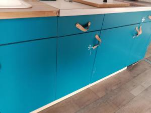 a kitchen with blue cabinets and a counter top at Logement pleine nature in Saint-Bris-le-Vineux