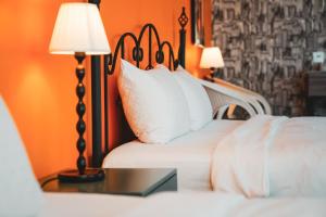 una camera da letto con un letto con cuscini bianchi e 2 lampade di Canaan B&B Kenting a Eluan Altre 22 foto