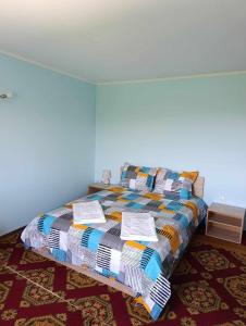 a bedroom with a bed with a colorful quilt on it at Винарна-Славовица in Kalugerovo