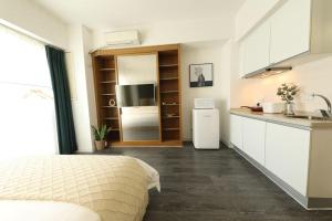 a bedroom with a bed and a kitchen with a sink at Shanghai Hills & Wanda Side Spacious Stay Close to Metro Line 18 in Shanghai