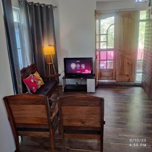a living room with a flat screen tv and a couch at Wahab's INN - riverside cottage in Srinagar