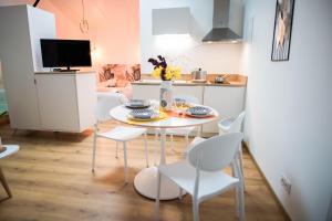 a small kitchen with a white table and chairs at L'Atelier Dollonnais in Dollon