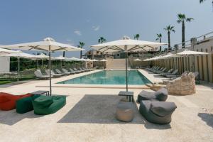 a swimming pool with lounge chairs and umbrellas at Helios Blue Villas Kriopigi Kassandra in Kriopigi