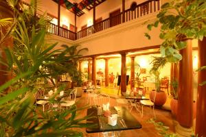 a large lobby with tables and chairs and plants at Maison Perumal Pondicherry - A CGH Earth Experience in Pondicherry
