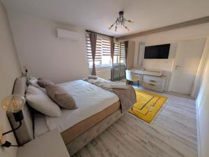 a bedroom with a bed and a desk and a television at Villa Saraj with Swimming Pool & Jacuzzi near Sarajevo in Sarajevo