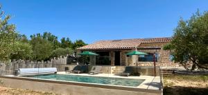 a house with a swimming pool with chairs and umbrellas at Villa Opaline in Issirac