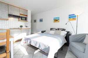 een slaapkamer met een bed en een bank en een keuken bij Dampfer 1 Westwind in Laboe