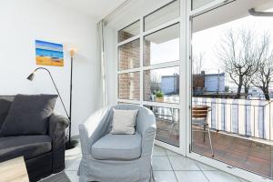 een woonkamer met een bank en een stoel bij Dampfer 1 Westwind in Laboe +29 foto's