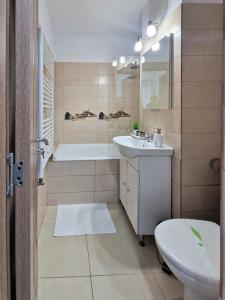 Un baño con bañera, lavabo e inodoro. en Relax Home, en Curtea de Argeş