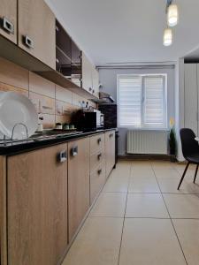 cocina grande con armarios de madera y ventana en Relax Home, en Curtea de Argeş