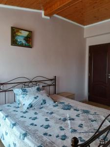 een slaapkamer met een bed met een blauw en wit dekbed bij Vila cu Flori in Eforie Sud
