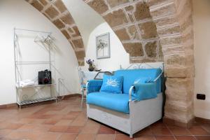 a blue couch in a room with a stone wall at HABITATIO MALLORCa in Alghero
