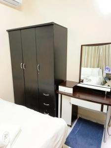 a bedroom with a dresser and a desk with a mirror at Ajman Friends Downtown Apartment Fully Yours Two Rooms and Kitchen for 3 People in Ajman 