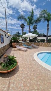 a resort with a swimming pool and palm trees at Villa CARLOTTA in Brucoli