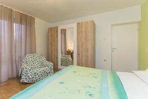 a bedroom with a bed and a chair at Apartment Amalia in Labin