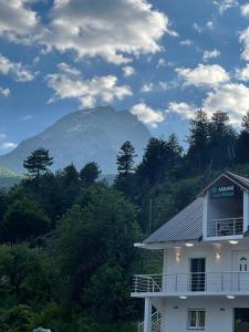 a building with a mountain in the background at Ardiani Guesthouse in Valbonë
