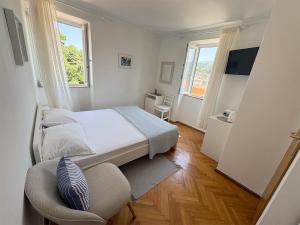 a small bedroom with a bed and a chair at Rooms Old Town in Rab