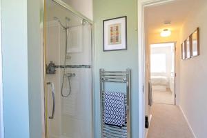 a bathroom with a shower with a glass door at Finest Retreats - Strand Mews in Bude +19 photos