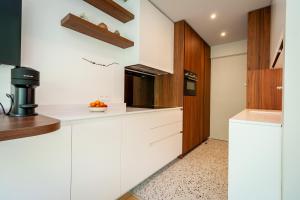 a kitchen with white counters and wooden cabinets at Lac & Nest in Annecy