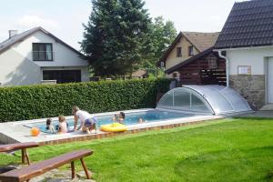 a group of children playing in a swimming pool at Red Pine Apartments in Vlachovice