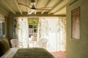 a bedroom with a ceiling fan and a window at La Folie Barbizon in Barbizon