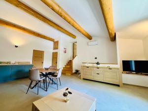 a living room with a table and a tv at La tanière d'Agoult in Goult