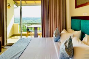 a bedroom with a bed and a balcony with a table at The Hills By First Team in Kandy