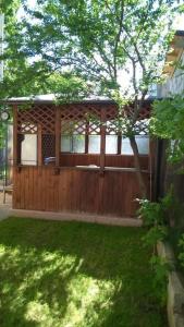 een houten gebouw met een boom in een tuin bij Vila cu Flori in Eforie Sud