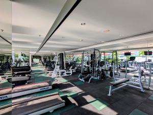 a gym with several treadmills and machines at Grand Zuri Cikarang Jababeka in Cikarang