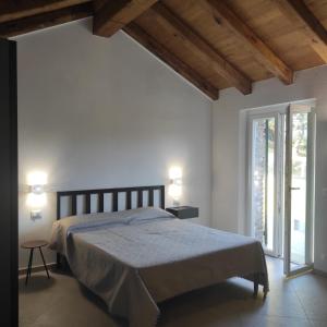 a bedroom with a bed and a large window at Vento di Mare - Tramontana con spiaggia privata in Moneglia