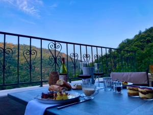 a table with plates of food on a balcony at Domaine l'Esquiròu - L'Insolite PALLAS in Asperjoc
