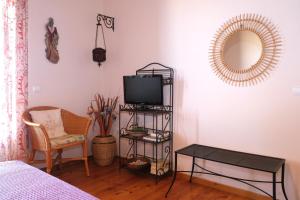 a room with a television and a chair and a table at Vereniki Andros guesthouse in Batsi