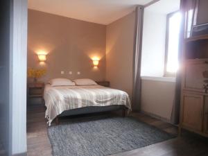 a bedroom with a bed and a window and a rug at La vallée de Gaïa in Saint-Hilaire-de-Lavit