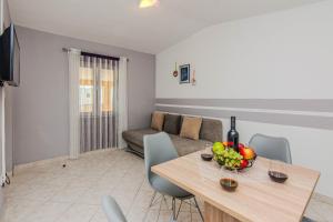 a living room with a table and a couch at Apartments with parking spaces Zukve, Zadar - 24559 in Nin