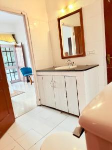 un baño con lavabo y espejo en The Solan Greens, en Solan