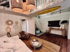 a living room with a couch and a surfboard on the ceiling at Beach Lifestyle Bungalow in Motu Tiahura