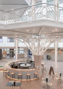 a large lobby with tables and chairs in a building at Octagon - Self Check In by Homenhancement in Geneva