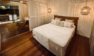 a bedroom with a bed with white sheets and pillows at Beach Lifestyle Bungalow in Motu Tiahura