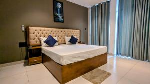 a bedroom with a large bed with blue pillows at Royal Lion Hotel - Kandy Road, Galagadara in Galagedara