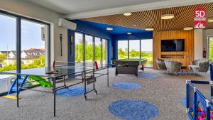una stanza con tavolo da ping pong e pallina da ping pong di Apartament SPA 2 USTRONNIE Residence - 5D Apartments a Ustronie Morskie
